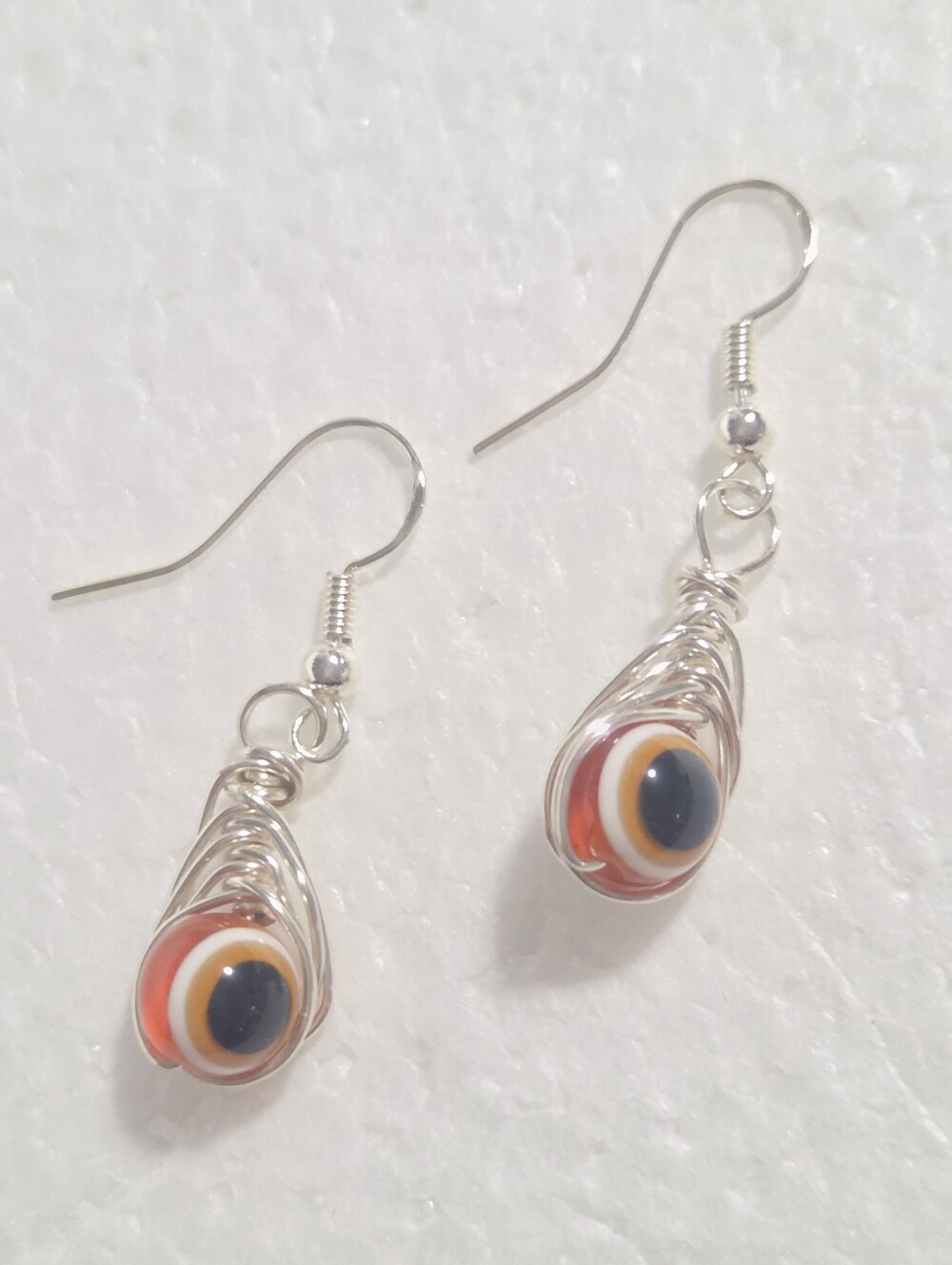 Handcrafted Silver Wire Teardrop Earrings with Orange Evil Eye Glass Beads